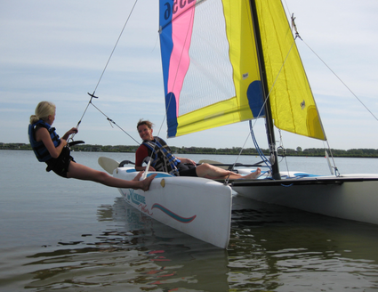 Twee personen op catamaran op water.