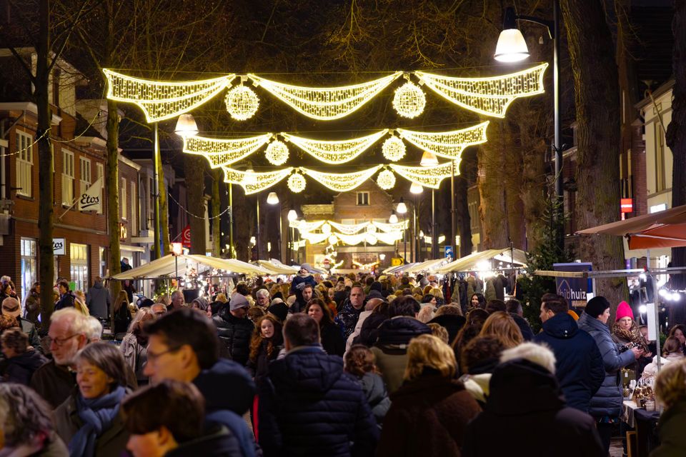 De verlichte Dorpsstraat in Oisterwijk met kramen en veel bezoekers.