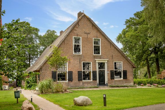 De voorkant van de groepsaccommodatie in Ruinerwold, veel uitzichten van de prachtige omgeving en een prachtige speeltuin