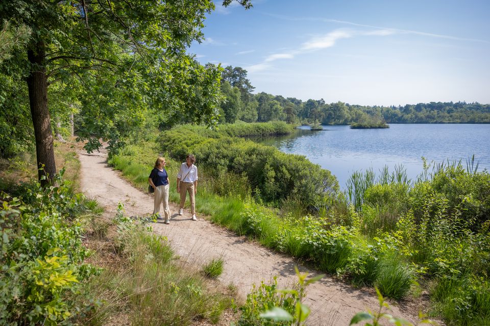 Twee vrouwen wandelen al kletsend over het met veel groen omgeven pad langs het Voorste Goorven