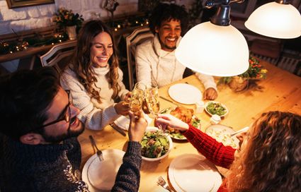 een groepje mensen die proosten tijdens het kerstdiner