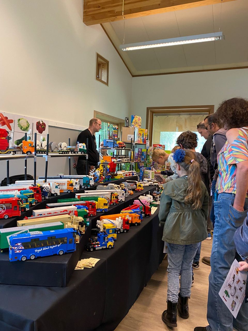 Kinderen kijken bij miniatuur vrachtwagens gemaakt van LEGO