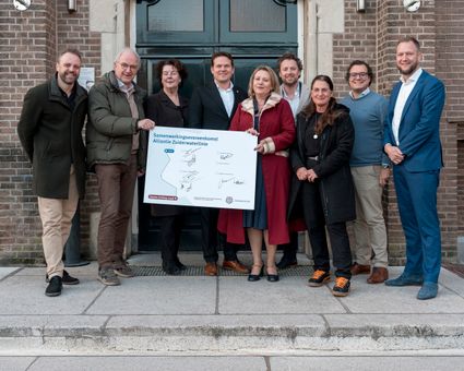 Groep mensen staat voor gebouw met handtekeningenbord in de hand