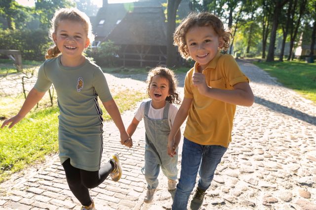 Kinderen rennen hand in hand lachend door een Drents brinkdorp.