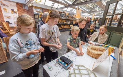 Kinderen aan de slag met verschillende materialen in het Nationaal Vlechtmuseum in Noordwolde.