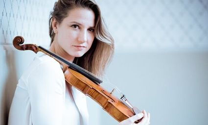 Portret van violiste Rosanne Philippens met viool in de hand, gefotografeerd door Simon van Boxtel.