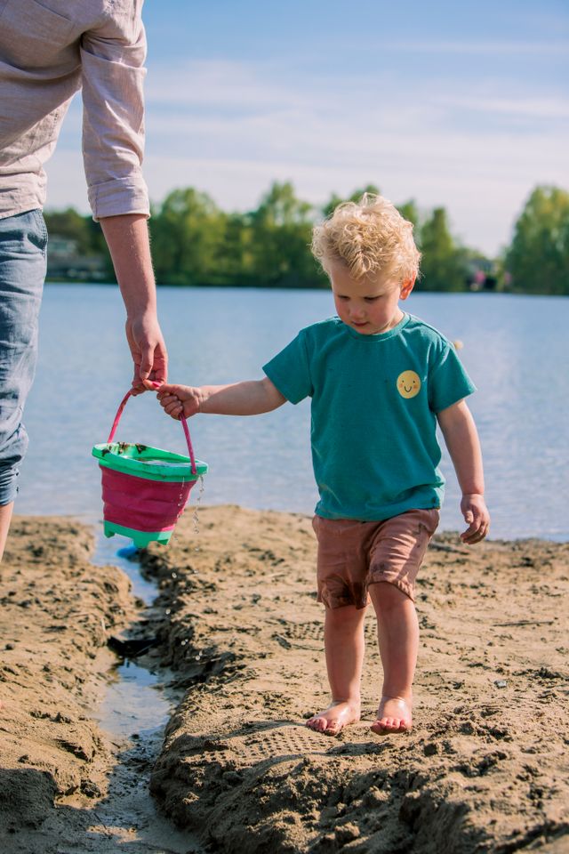 Jongen speelt in het zand.