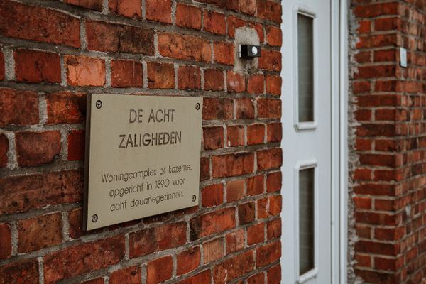 Bord aan woning met daarop uitleg over de douanewoningen