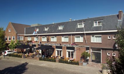 Terras en voorzijde van Restaurant Het Wapen van Harmelen in Harmelen met gezellige zitplekken en dorpse uitstraling op een zonnige dag.
