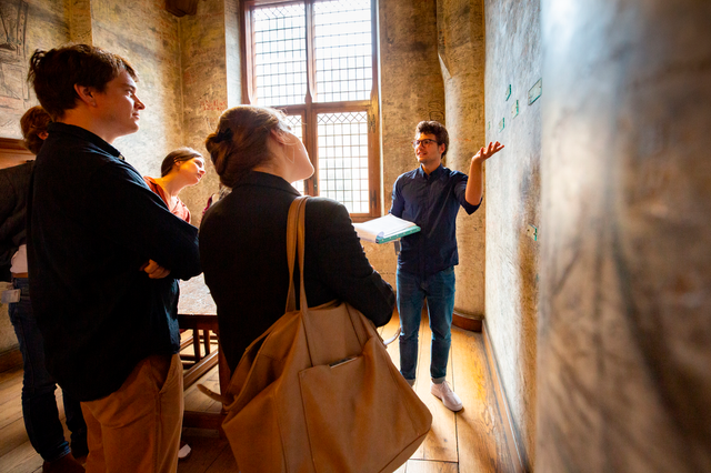 Een student geeft een rondleiding door het academiegebouw