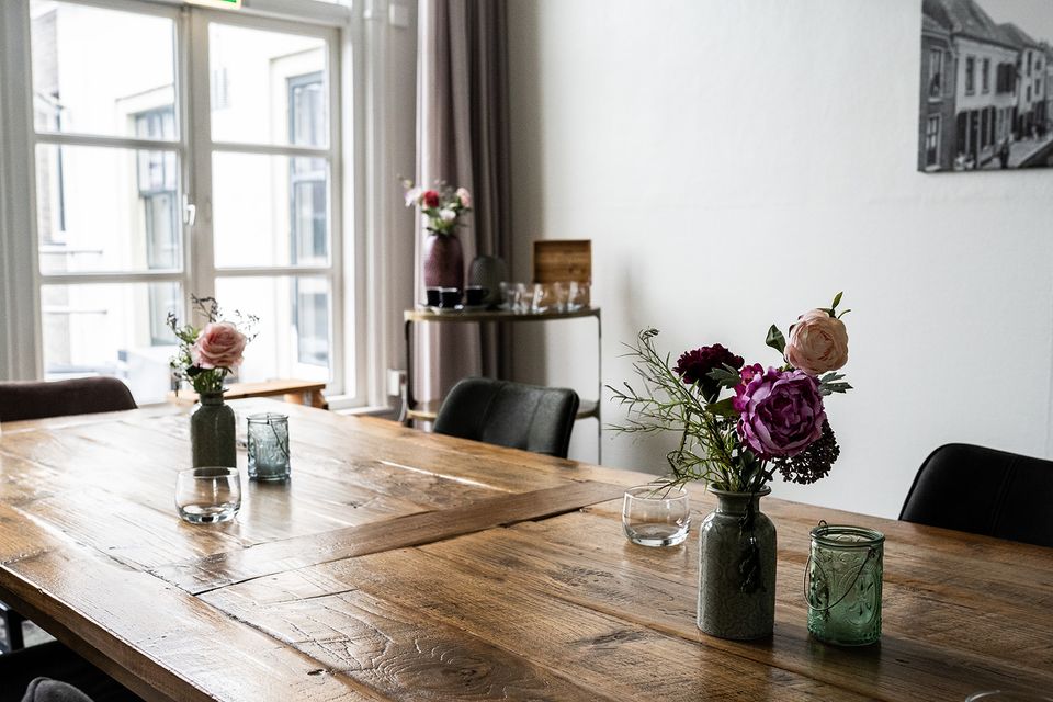 Houten vergadertafel met bloemen in de vergaderruimte van Plein 7 in Woerden.