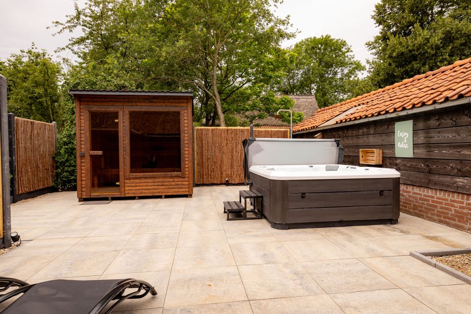 Een privé wellnessplein met sauna, jacuzzi en buitendouche