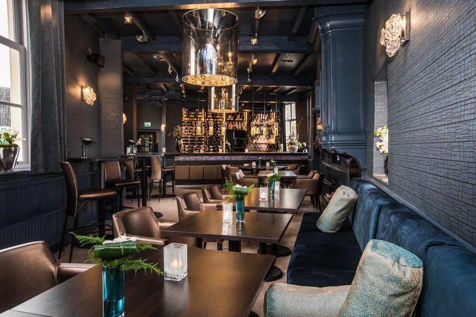Stijlvol interieur van Kasteel Montfoort met luxe restaurantsetting, donkere tinten, sfeervolle verlichting en elegant meubilair, historische locatie voor dineren en culinaire beleving in het Groene Hart.