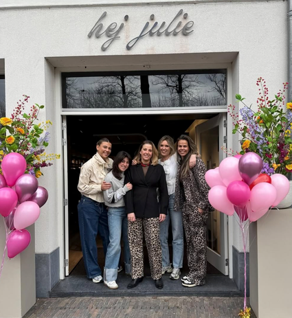 Het team van Hej Julie voor hun witte pand met ballonnen en bloemen