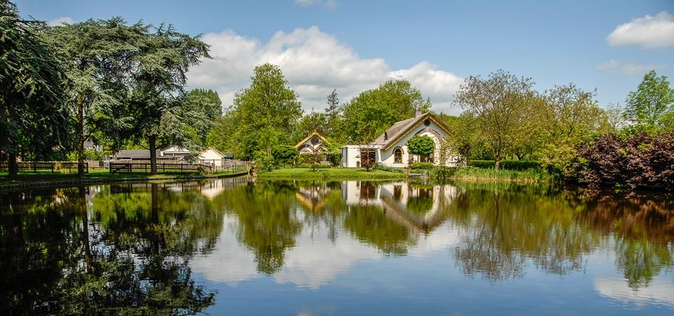 Sfeervol uitzicht op Landgoed Bredius in Woerden met vijver, bomen en historische gebouwen, locatie van het mini-festival met muziek en kunst