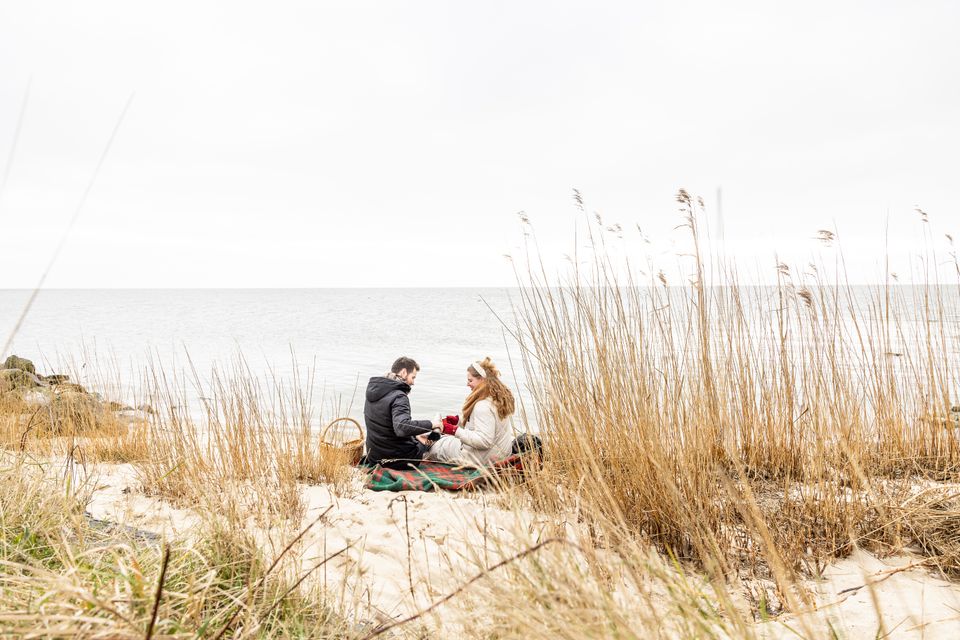 Een stel zit te picniccen tussen de winterduinen.