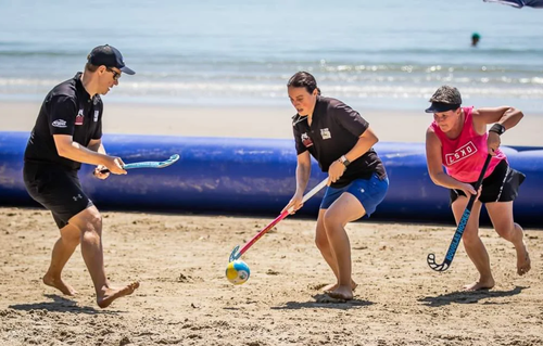 Mensen die beach hockey spelen