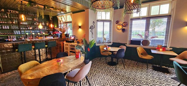 Interieur van 14tien met links de bar en in het midden en rechts tafels en stoelen