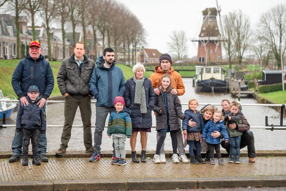 Een familiefoto op de brug bij de Hanspoort in Dokkum. Op de achtergrond het Westerbolwerk en molen Zeldenrust. In verband met privacy zijn de gezichten aangepast.