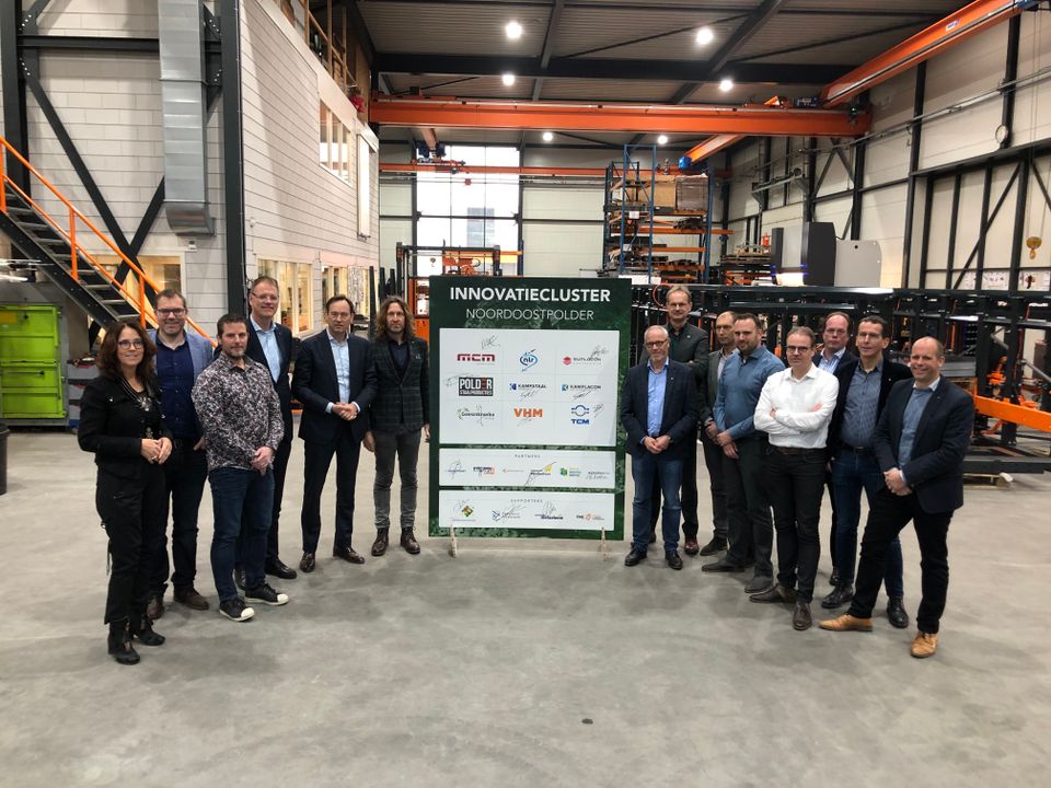 Mannen poseren voor een bord over Innovatiecluster in de Noordoostpolder, Flevoland