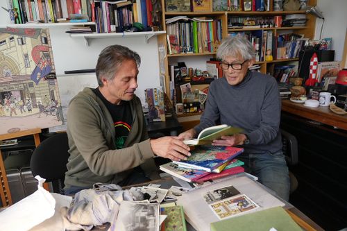 Twee mensen die in boeken aan het kijken zijn