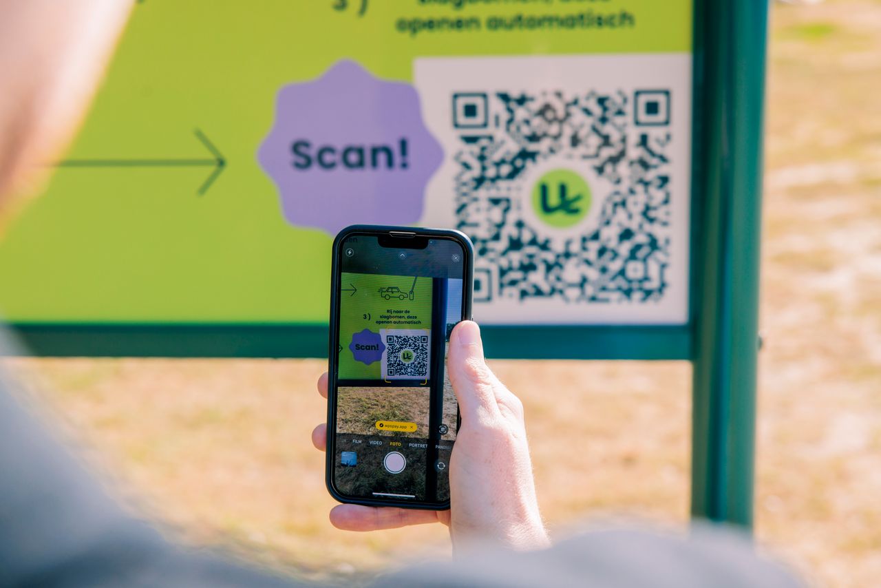 Jongen scant QR-code op recreatiegebied voor uitrijkaartje