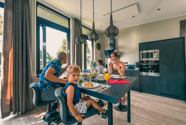 Familie aan de eettafel in een van de huisjes in Europarcs in Kaatsheuvel