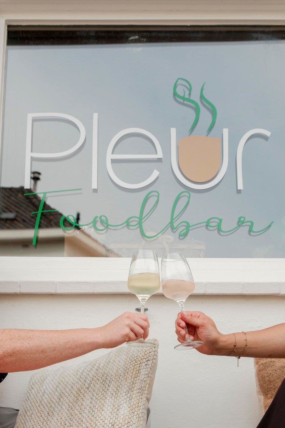 Pleur Foodbar Maastricht window with logo toasting glasses