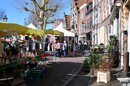 Stadscentrum weekmarkt met kramen en winkelend publiek in Oudewater, Groene Hart, historische straat met bakstenen gevels en lokale marktproducten.