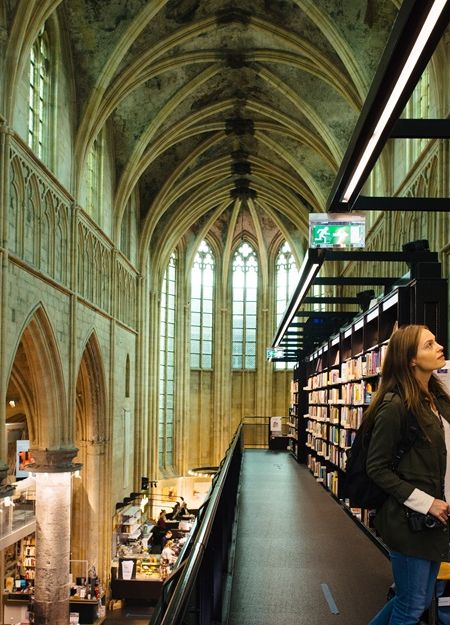 Dominicanen bookshop Maastricht inside shelves person