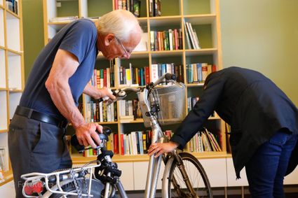 Twee mannen kijken naar kapotte fiets