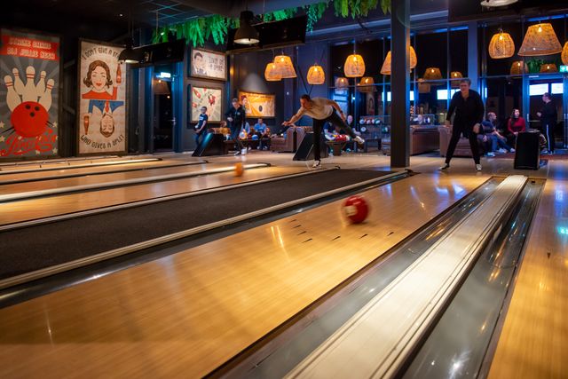 Bowlingbanen in Posta7 in Tolbert, met sfeerverlichting en eigen scoreschermen.