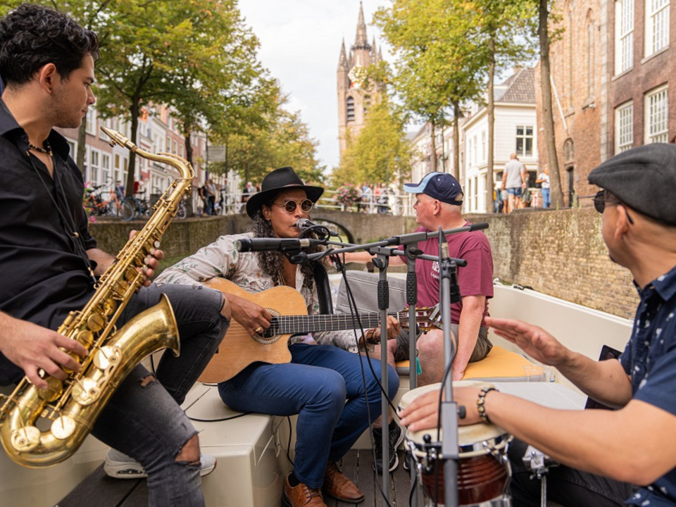 Muzikanten in een boot op de grachten van Delft tijdens het Knapsack festival