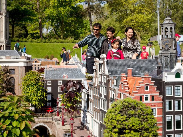 buitenlandse bezoekers bekijken de miniatuurgebouwen in Madurodam