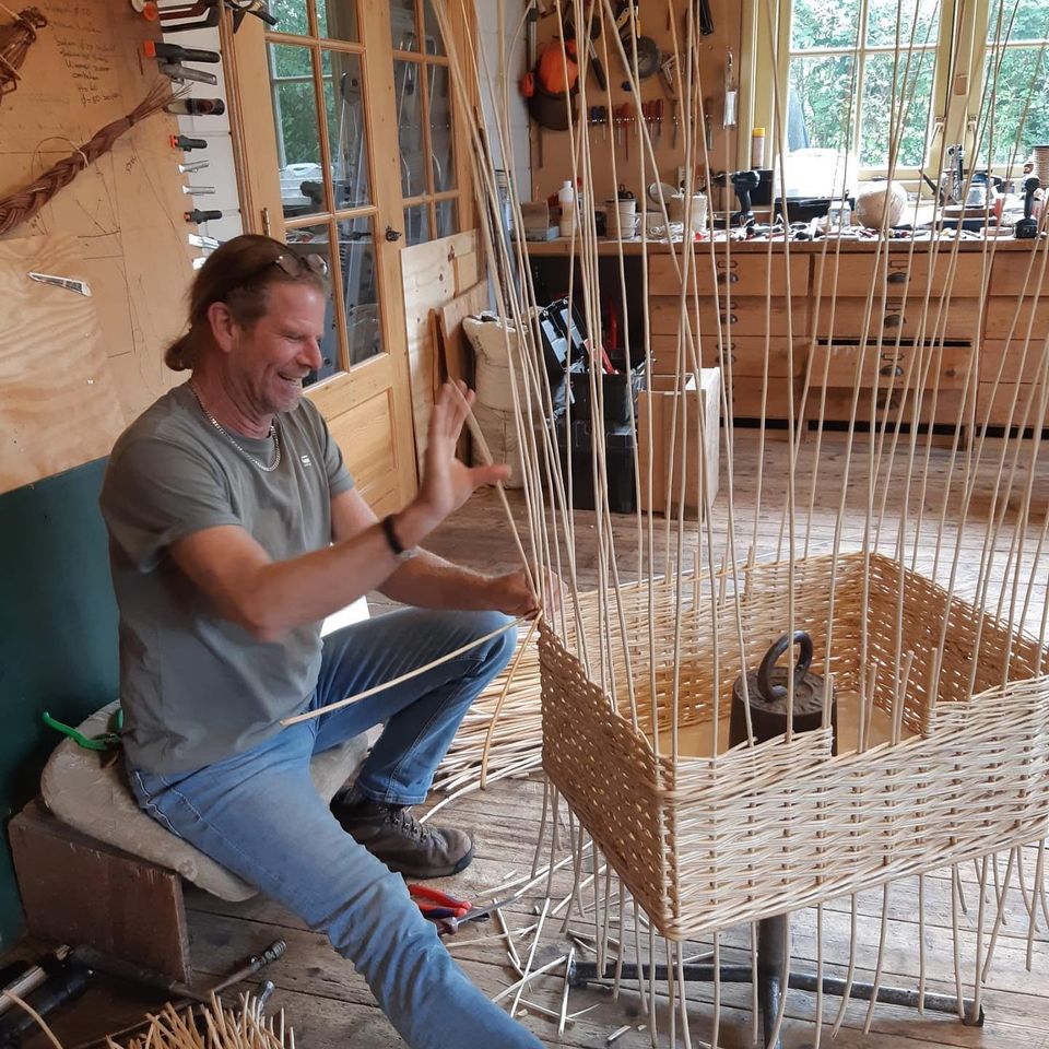 Ambachtelijke mandenmaker De Broedkorf in Oudewater, Groene Hart, eigenaar vlecht handgemaakte rieten mand van wilgentakken in werkplaats met traditioneel vlechtwerk en natuurlijke materialen.