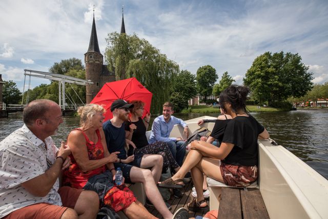 Groep mensen die een canal tour krijgen in de grachten van Delft