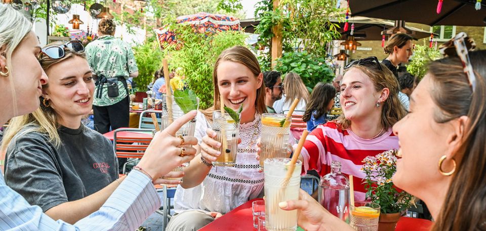 Meiden die proosten op een terras in Delft