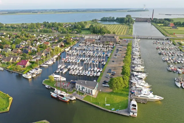 Sporthotel Iselmar in Lemmer van bovenaf met zicht op de haven vol met zeilboten en het water rondom.