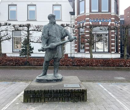 bronzen beeld van smid met klepel in de hand