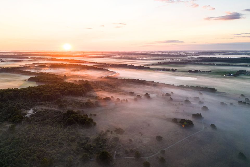 Luchtfoto van een mistig natuurgebied in Drenthe.