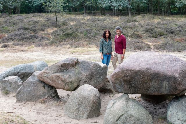 Man en vrouw kijken naar een hunebed.