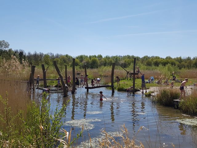 Kinderen spelen in het water van het Belevenissenbos in Lelystad, Flevoland