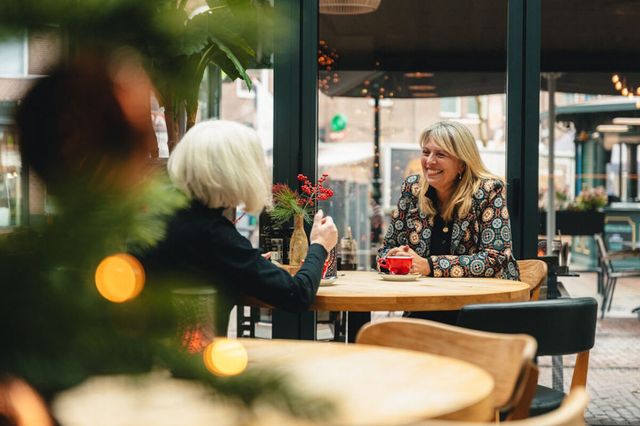 Zwei Frauen genießen gemütlich eine Tasse Kaffee in einem Café in Drenthe.