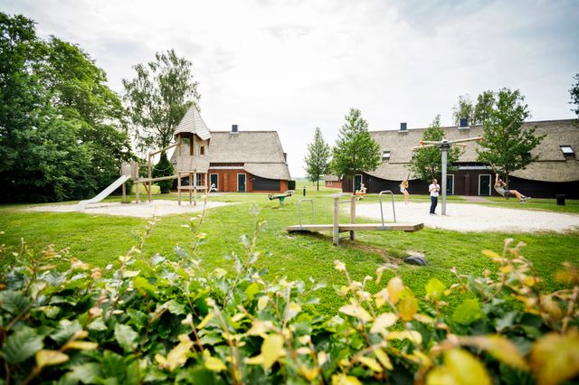 Kinderen spelen in een speeltuintje op een vakantiepark.