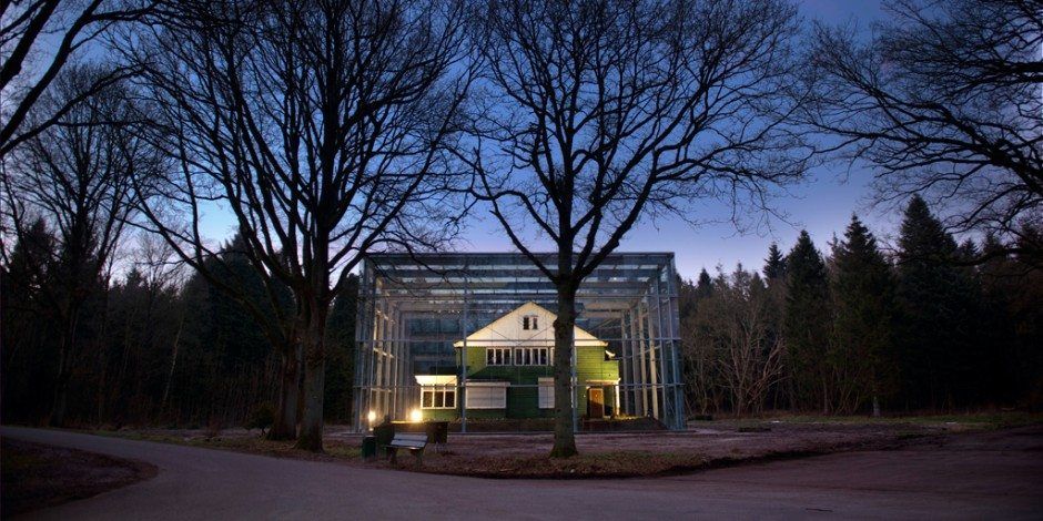 De verlichte kampcommandantswoning in de avond.