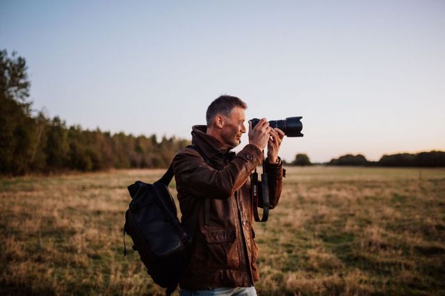 Een man  maakt een foto met een fotocamera