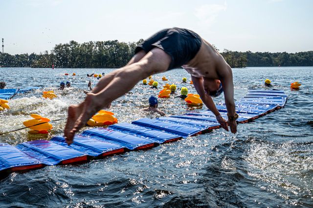 Deelnemer duikt in de IJzeren Man tijdens het evenement Swim to Fight Cancer