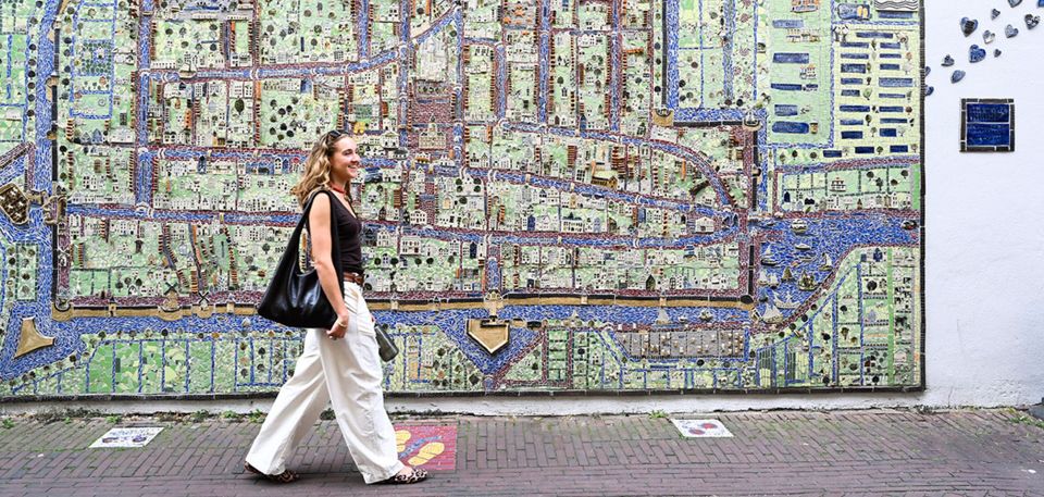 Meisje loopt langs de keramieken kaart van Delft