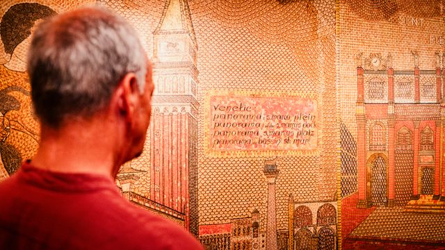 Een man in het Volendams Museum die kijkt naar een kunstwerk