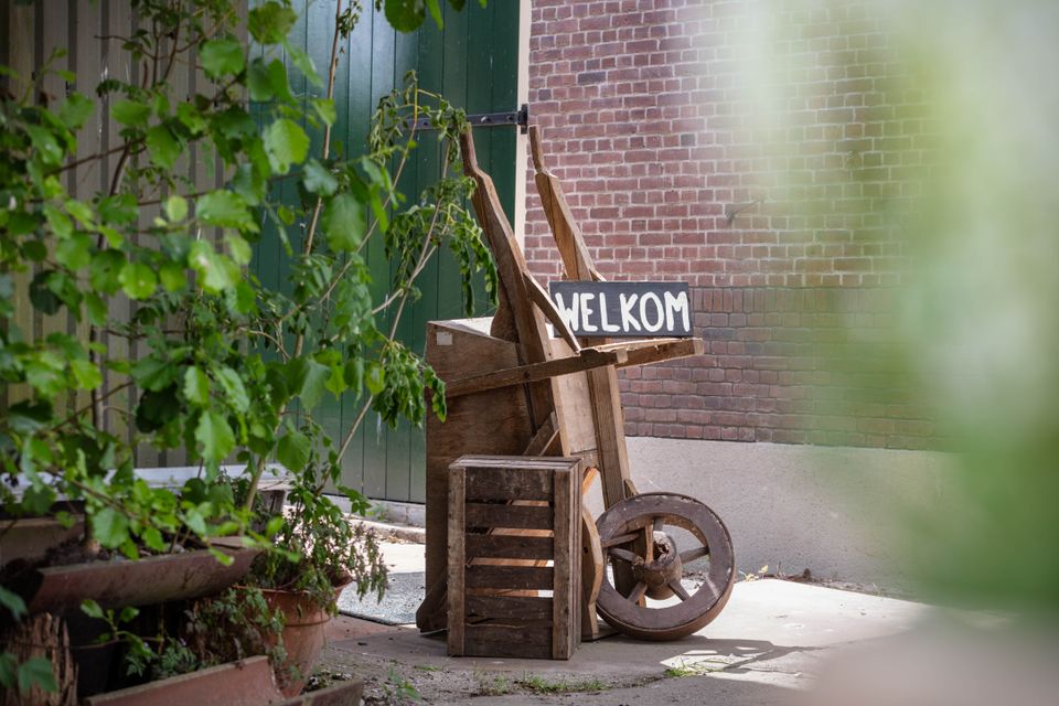 Rustiek welkomstbord bij biologische boerderij De Beekhoeve in het Groene Hart, met houten elementen en landelijke uitstraling bij de entree van het erf.